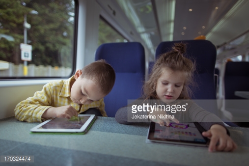 خواهر و برداری که در قطار از تبلت استفاده می‌کنند